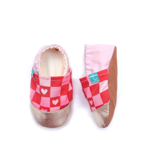 Widok boczny kapci Titot Sweet Hearts, pokazujący miękką jasnoróżową piętkę oraz brązową, skórzaną podeszwę barefoot.