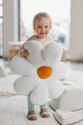 Dziecko trzymające dużą pluszową stokrotkę w trampkach Titot Blue Daisy.