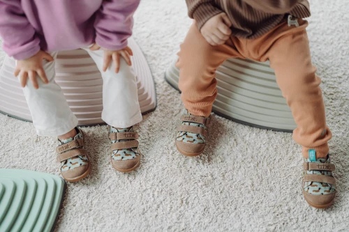 Dwa maluchy w tenisówkach Hot Doggy podczas radosnej zabawy.