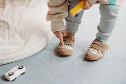 Dziecko wskazujące paluszkiem na wzór koparki na skórzanym nosku buta City Builders.