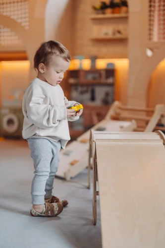 Mały inżynier w pełnej stylizacji Titot z trampkami City Builders na placu zabaw.