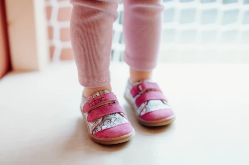 Stópki dziecka w tenisówkach TITOT Rainbow Unicorn z fioletowymi zamszowymi detalami.