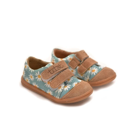 Dziecięce tenisówki Blue Daisy na białym tle ustawione pod kątem.