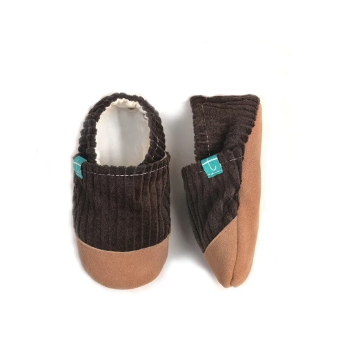 Kapcie Cuddly Brown z widoczną elastyczną gumką wokół kostki i miękką skórzaną podeszwą.